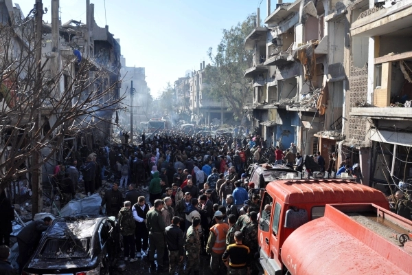 تدجمع حول موقع في حمص شهد انفجارا بسبارة مفخخة (أ ف ب)