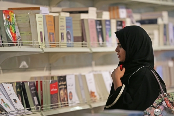 
    زائرة تقرأ عناوين الكتب