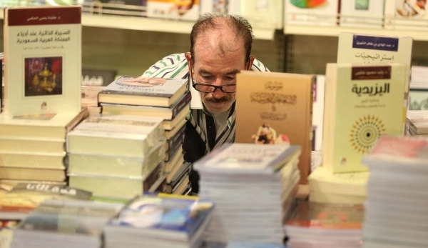 
    قارئ يبحث بين الكتب