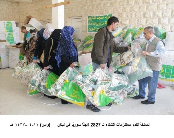 لاجئون سوريون خلال تسلمهم المساعدات السعودية (واس) 