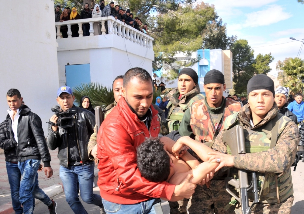 
    تونسيون يحملون شابا حاول الانتحار أمس في القصرين (أ ف ب)
