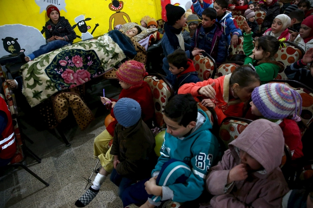 أطفال يشاركون في فعاليات داخل مركز للدعم النفسي في دوما (رويترز)