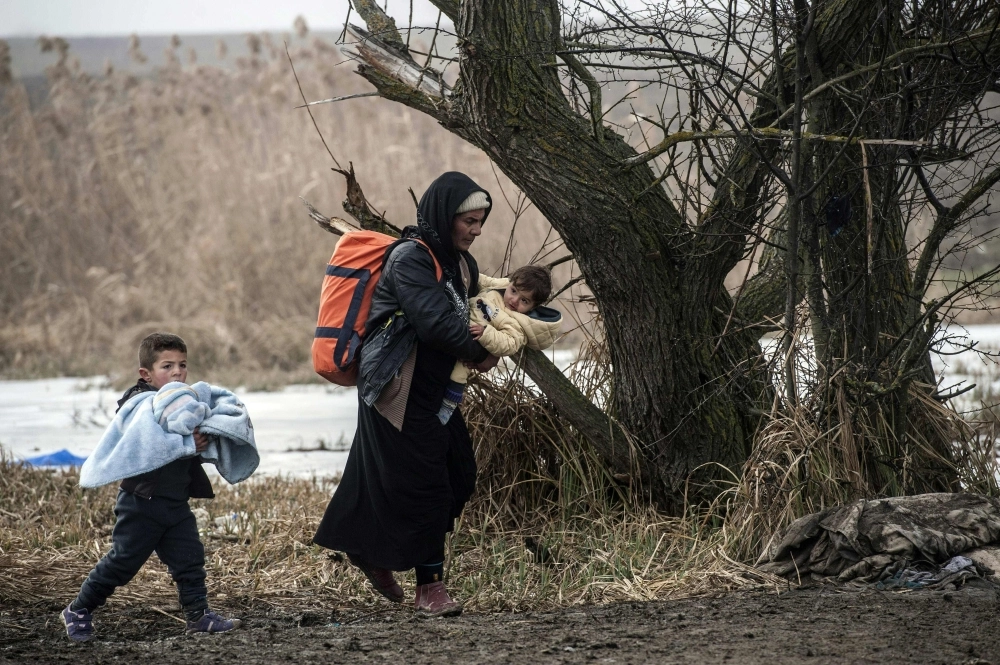 لاجئون سوريون يعبرون الحدود المقدونية في صربيا (أ ف ب)