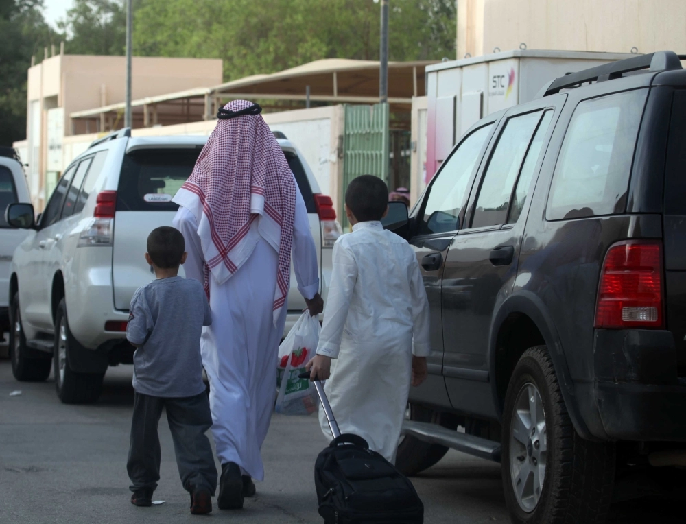 
    ولي أمر يوصل طفليه إلى مدرستهما (مكة)
