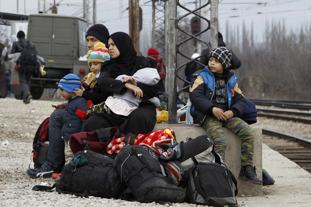 عائلة لاجئة في مركز عبور قرب قرية مقدونية (أ ف ب)