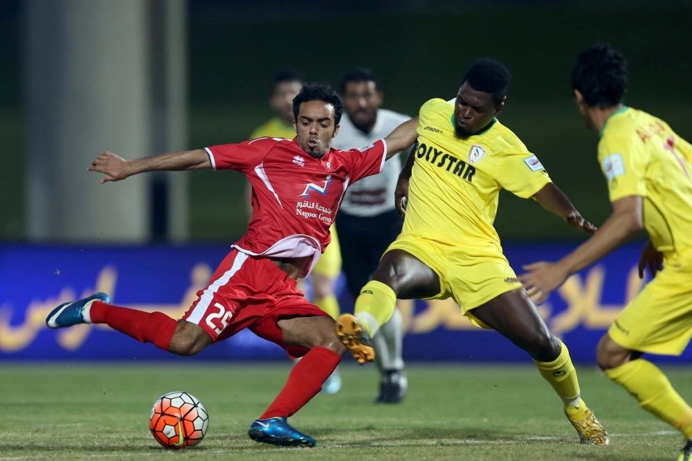 لاعب الوحدة علي الزقعان يحاول التسديد وسط مضايقة لاعبي نجران (ثامر الفرج)