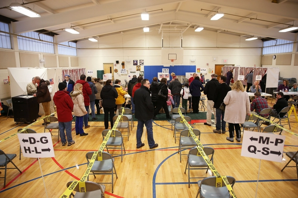 ناخبون في مقر انتخابي بنيوهامبشاير الأمريكية ( أ ف ب )