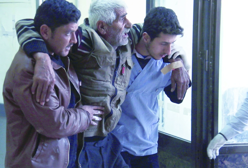 مسعفان يسعفان مسنا أصيب في غارات روسية بريف حلب            (أ ف ب)