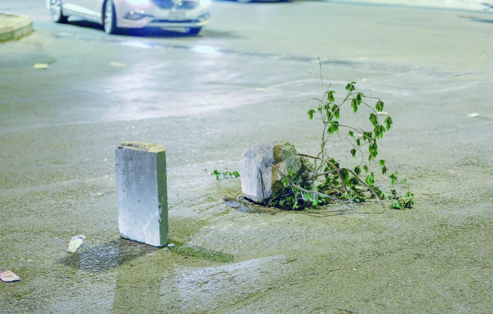 وضع الأحجار وأغصان الأشجار للتنبيه من حفرة تتوسط شارعا في مكة     (محمد عطية)