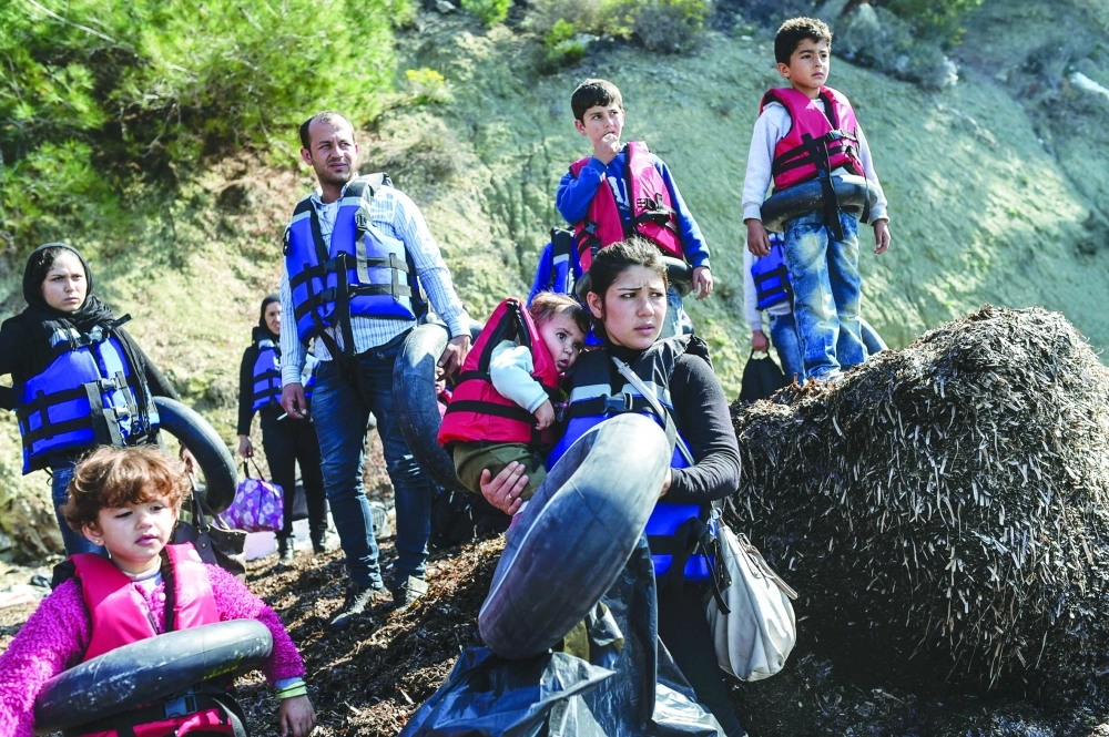 لاجئون سوريون يرتدون سترات النجاة قبل عبور بحر إيجة باتجاه أوروبا                              (أ ف ب)