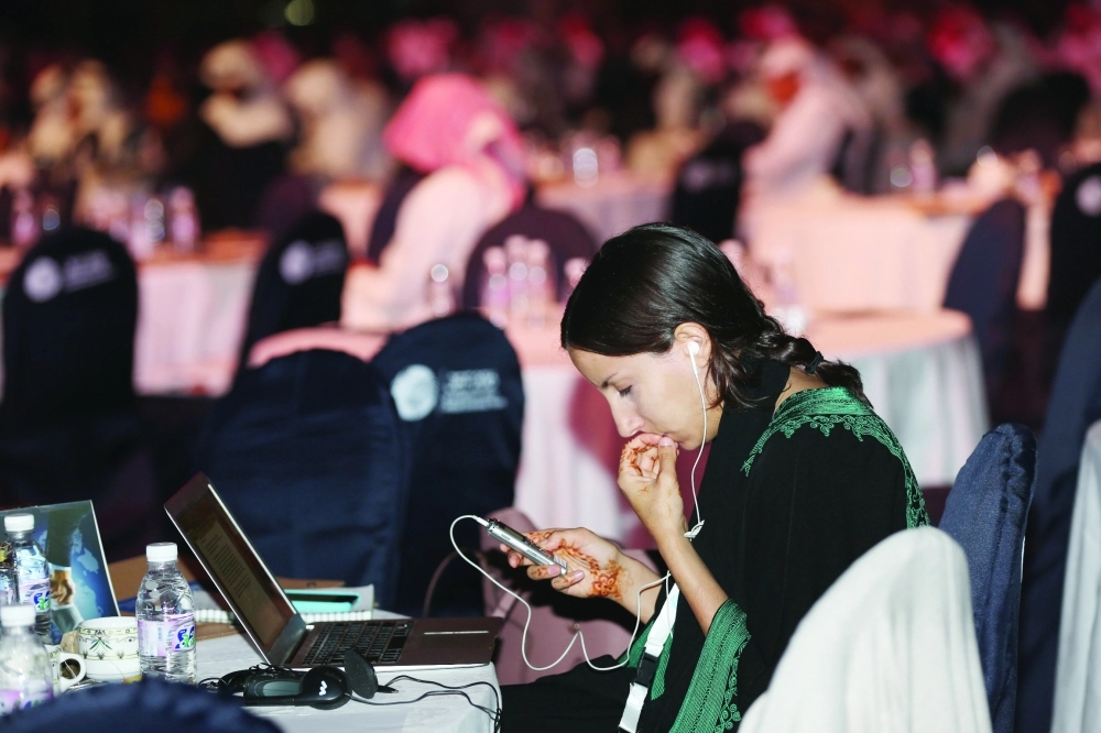 إحدى الحاضرات تراجع تسجيلا للجلسة            (غرم عسيري)