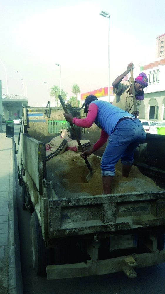 عامل يجهز الخلطة داخل حوض القلاب