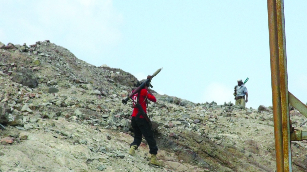 عنصران من الشرعية يتسلقان أحد المواقع في كرش   (أديب محمد)