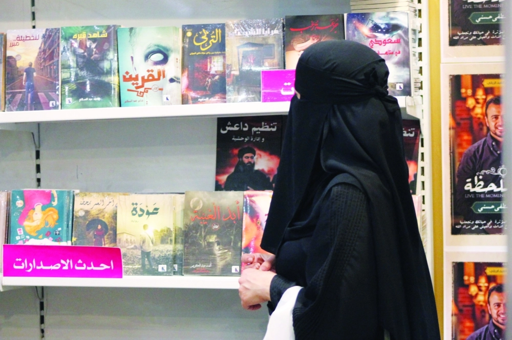 زائرة تطالع أحد الكتب عن داعش                    (أحمد الحمادي)