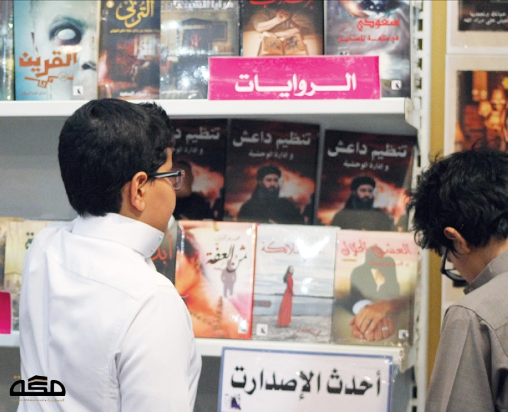 طفل يشاهد أحد الكتب عن داعش بمعرض الكتاب  (أحمد الحمادي)