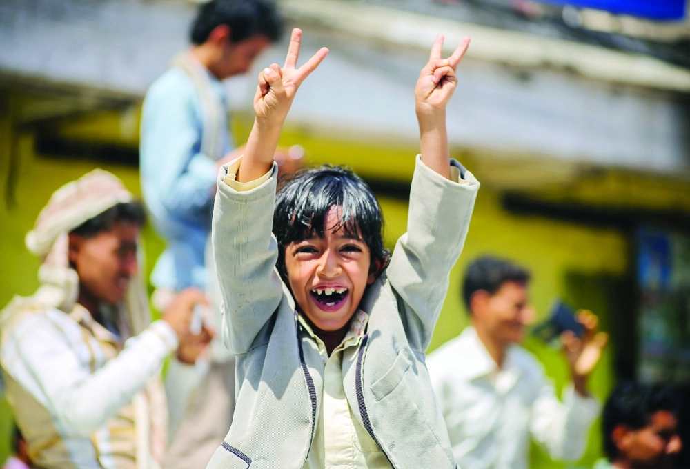 طفل في تعز يرفع علامات النصر فرحا مع أقرانه بكسر حصار المدينة  (أ ف ب)