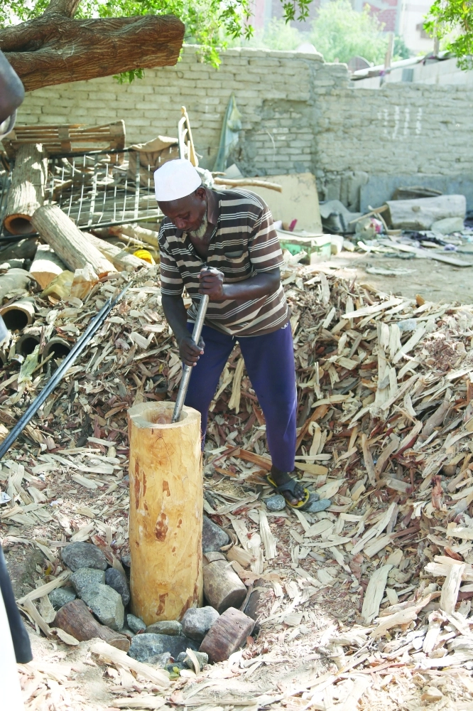وآخر يصنع عودا للنحل من الأشجار المزالة