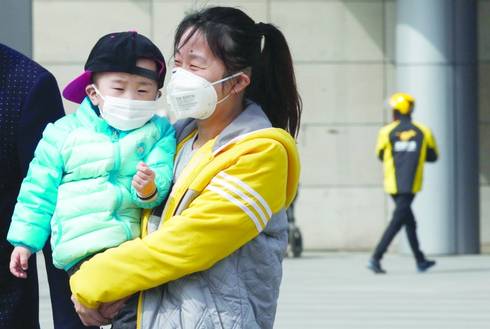 أم وطفلها يرتديان كمامتين بسبب تلوث الهواء في بكين   (إ ب أ)