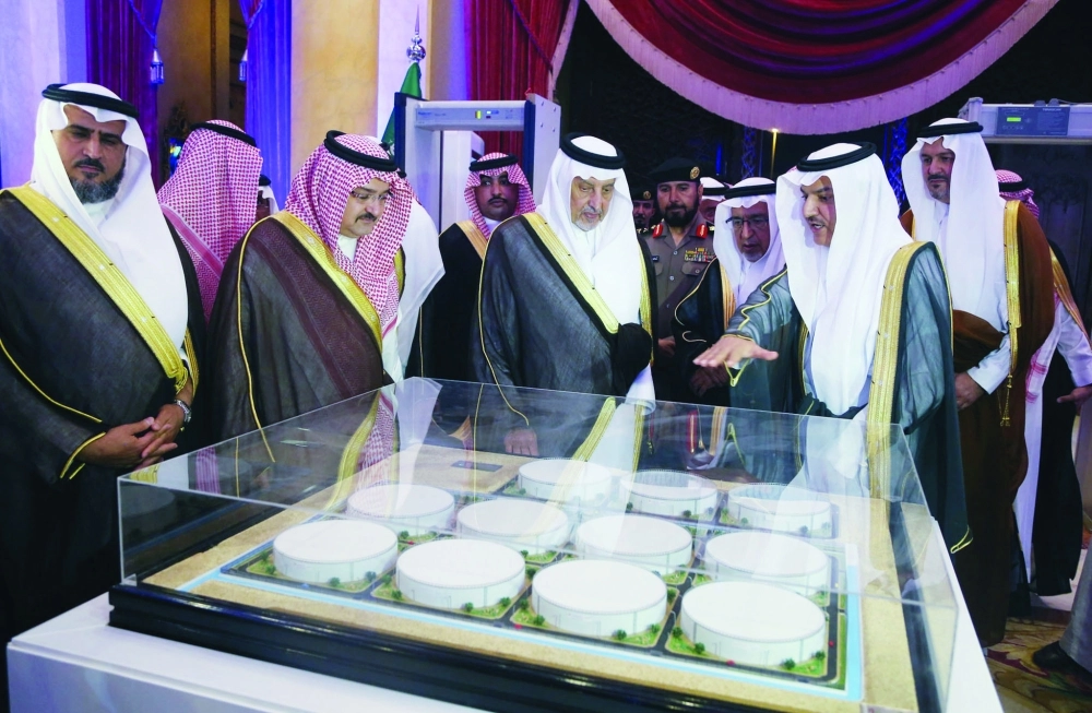 خالد الفيصل مطلعا على مجسم المشروع ويبدو مشعل بن ماجد وعبدالله الحصين         (علي القرني) 