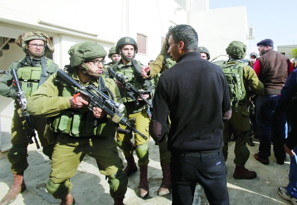 أحد الجنود الإسرائيليين يعترض فلسطينيا قرب نابلس           (رويترز)