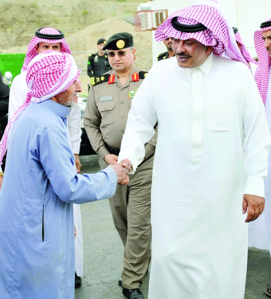 مشاري بن سعود مصافحا أحد المسنين داخل السوق        (واس)