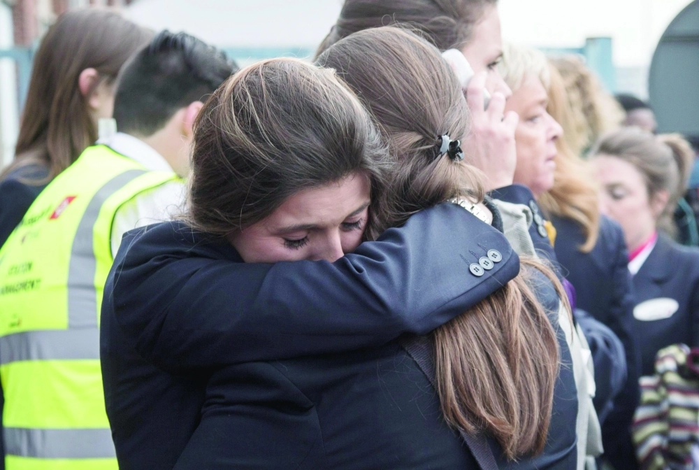 امرأتان تتبادلان المواساة بعد إجلائهما من مطار بروكسل                 (إ ب أ)