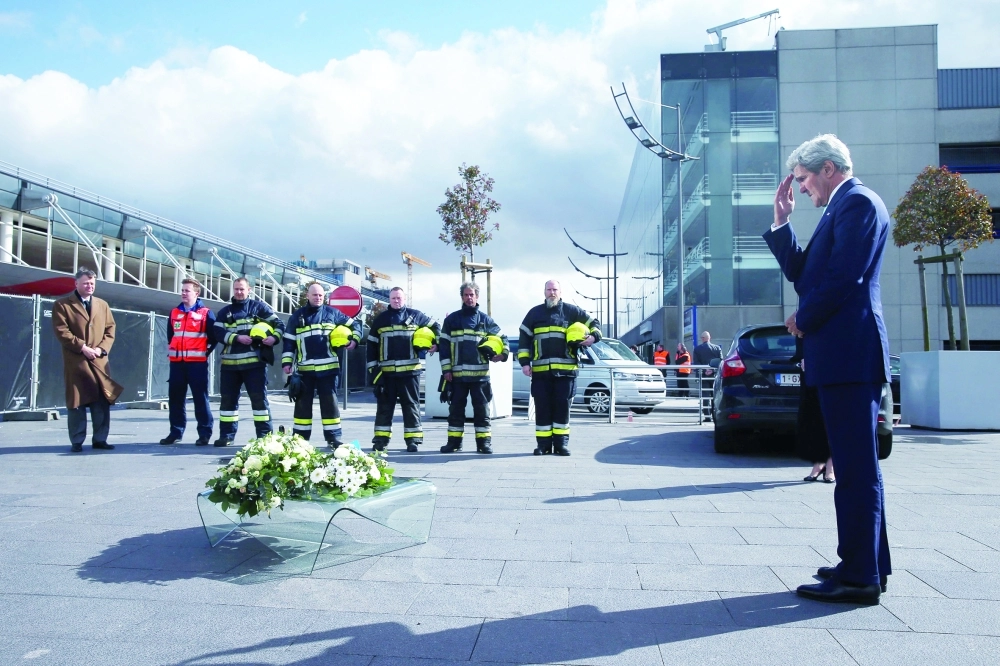 كيري يضع ورودا في موقع الاعتداءات ببلجيكا أمس                                                    (أ ف ب)