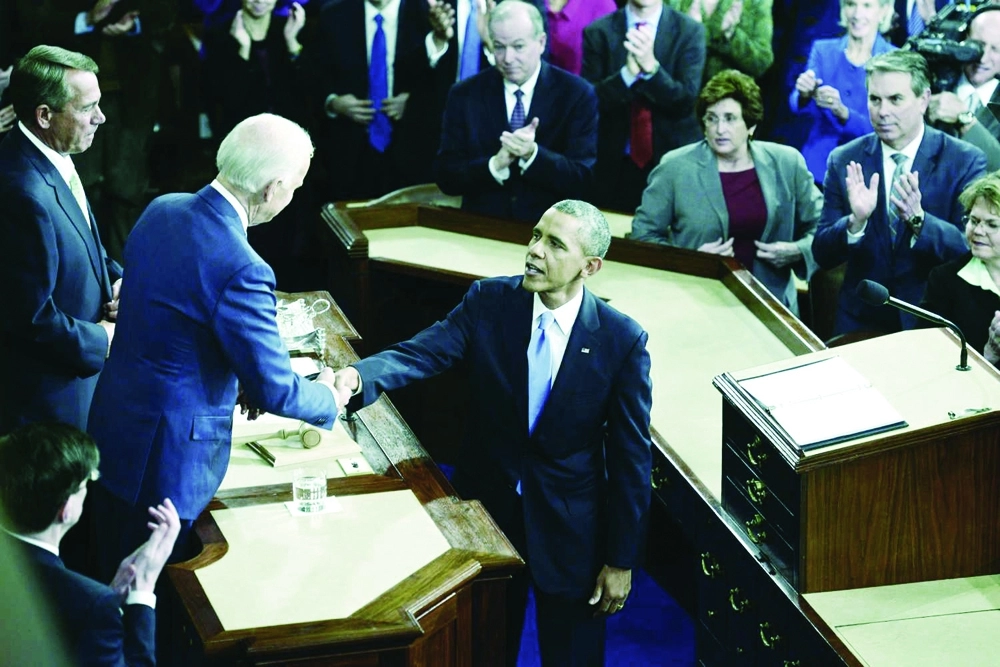  أوباما يصافح نائبه بايدن قبل إلقاء أحد خطابات الاتحاد بواشنطن       (أ ف ب)