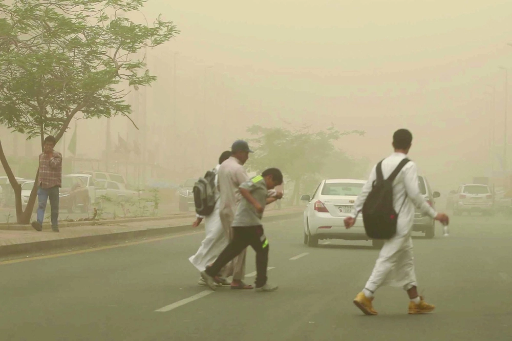 طلاب يعبرون طريقا أثناء الغبار بجدة أمس    (غرم عسيري)