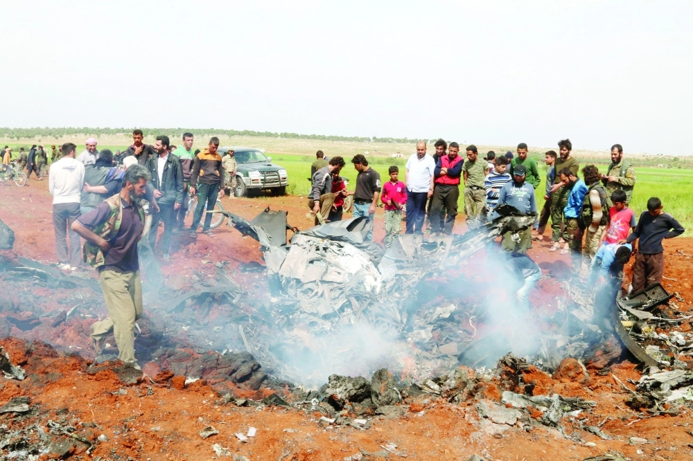 سوريون ومقاتلون ينظرون إلى حطام طائرة أسقطت قرب حلب                  (رويترز)