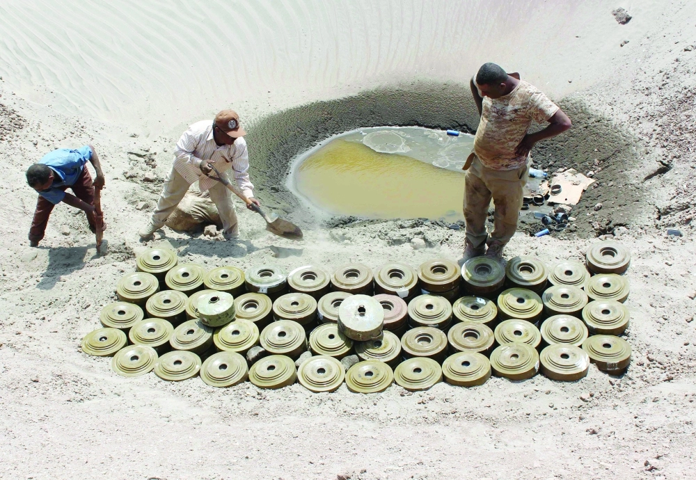 خبراء مفرقعات يجمعون ألغاما زرعها الحوثيون في عدن تمهيدا لتفجيرها                      (أ ف ب)