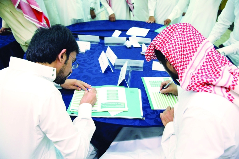 شابان أثناء تعبئة استمارات توظيف في غرفة مكة المكرمة                (مكة)