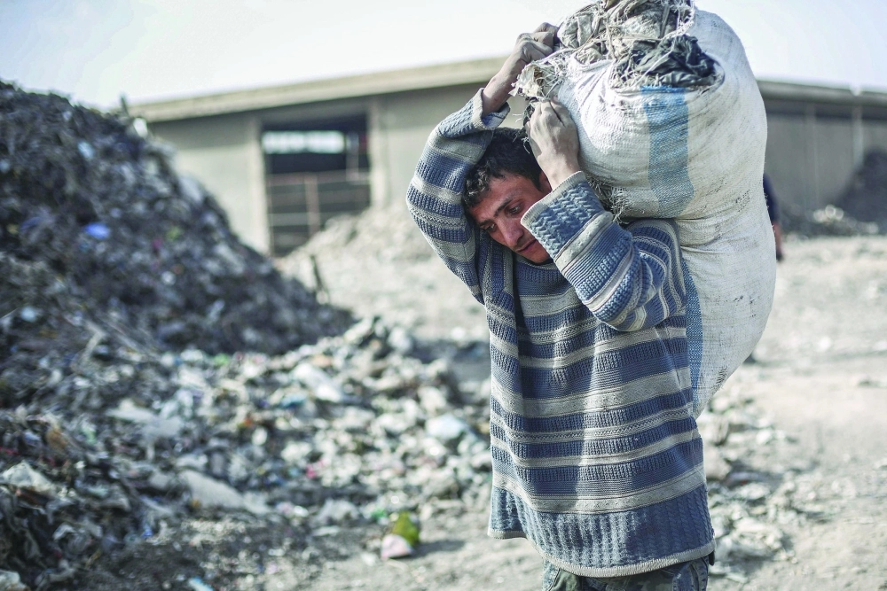 سوري يحمل مواد قابلة للتدوير في دوما                                   (إ ب أ)