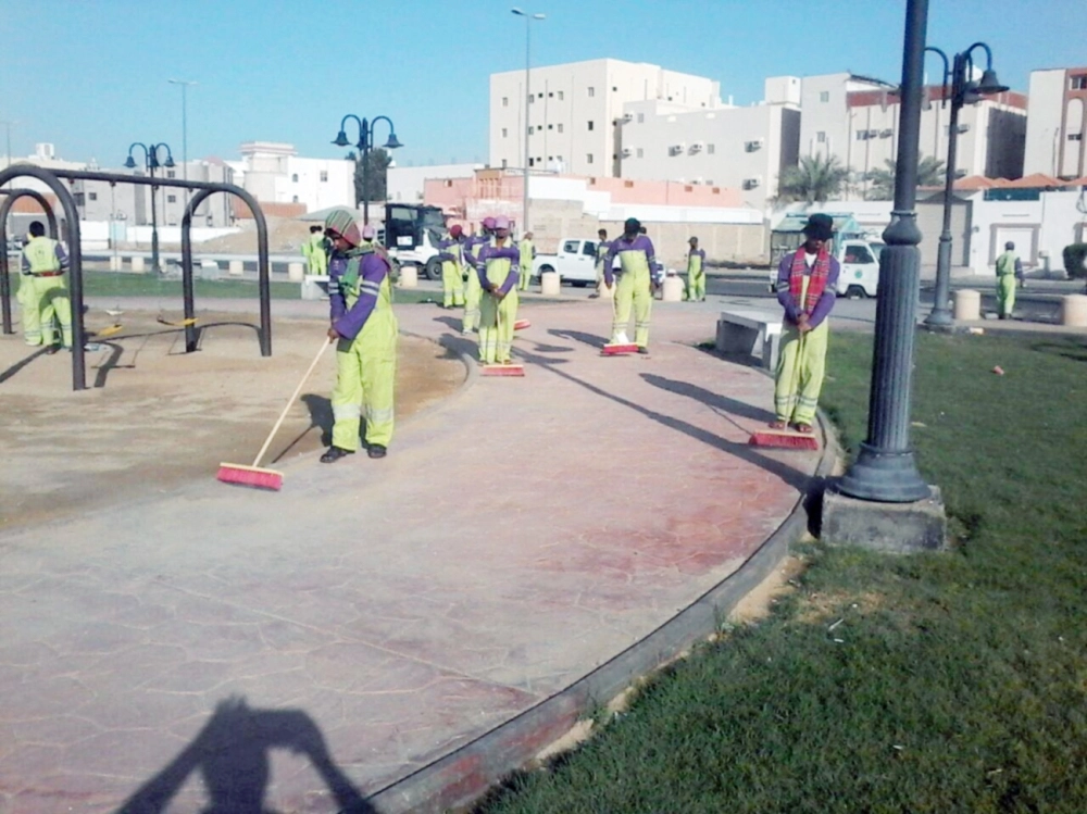 عمال النظافة أثناء تنظيف إحدى الحدائق        (مكة)