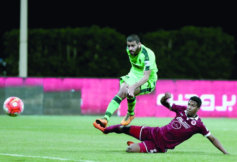 مصطفى بصاص يسدد الكرة وسط مضايقة المدافع عبدالله المحمد               (إ ب أ)