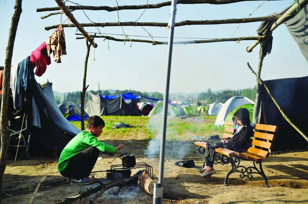 طفلان سوريان لاجئان قرب الحدود اليونانية المقدونية                        (أ ف ب)