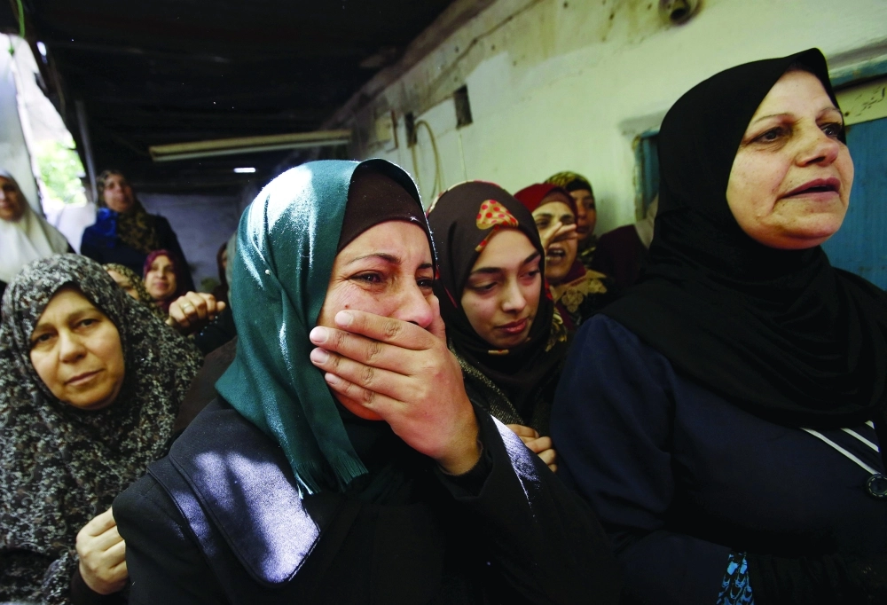 فلسطينيات ينتحبن خلال تشييع جثمان شهيد قرب الخليل                 (رويترز)
