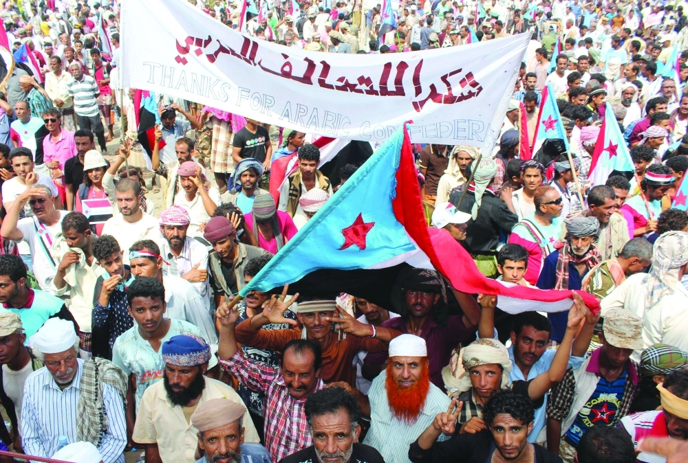 يمنيون بعدن يرفعون شعارا مؤيدا للتحالف