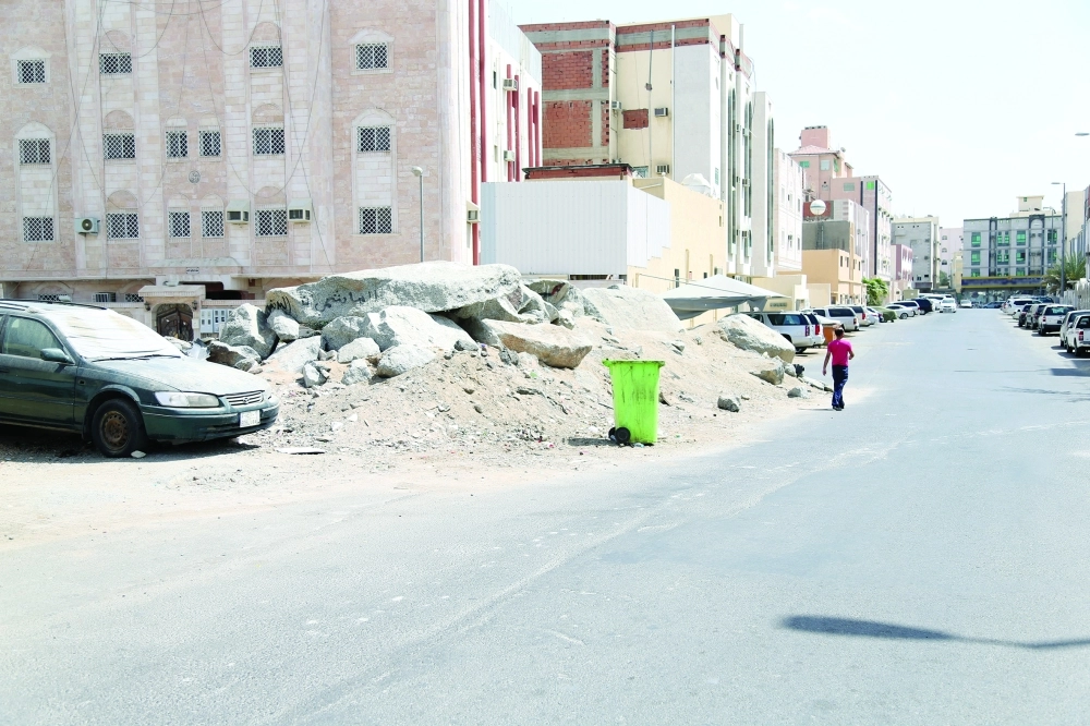 أكوام من الصخور والأتربة تعترض شارعا بحي البحيرات                                    (أحمد جابر)
