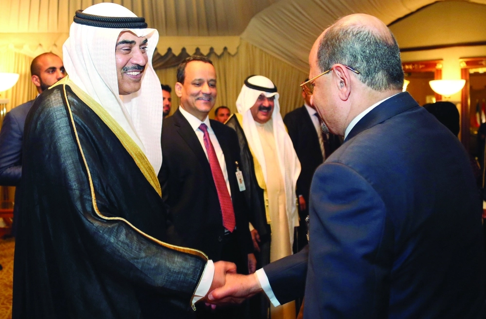 وزير خارجية الكويت، بجواره ولد الشيخ، يصافح أعضاء الوفود لدى وصولهم قصر بيان بالكويت أمس       (أ ف ب)