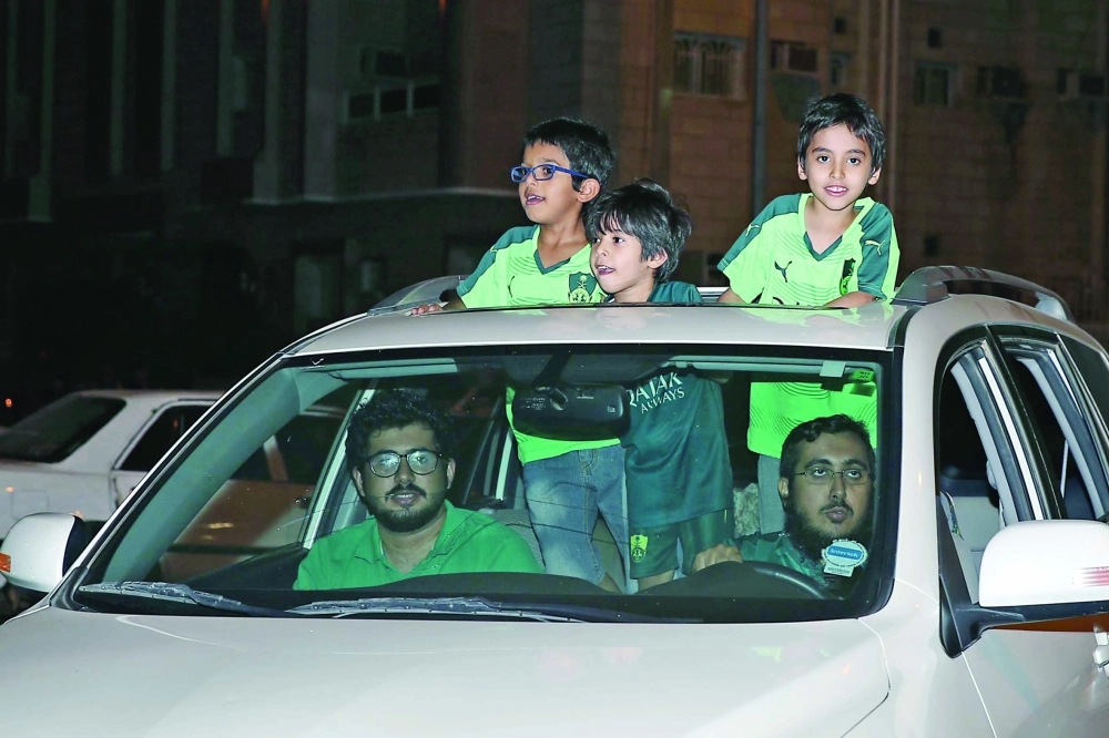 أطفال يرتدون شعار الأهلي مع أولياء أمورهم في شوارع جدة (ثامر الفرج)