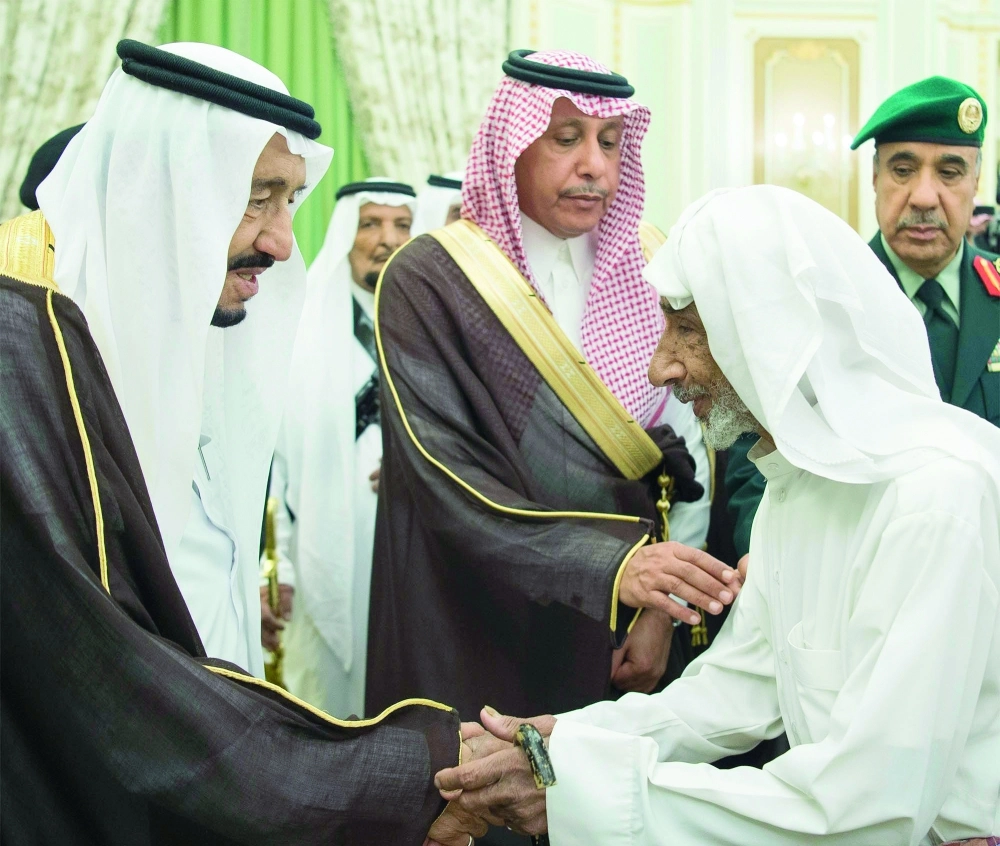 الملك سلمان مصافحا أحد المسنين لدى استقباله وزير العمل وممثلي المهن والعاملين بالقطاع الخاص في قصر اليمامة أمس   (واس)