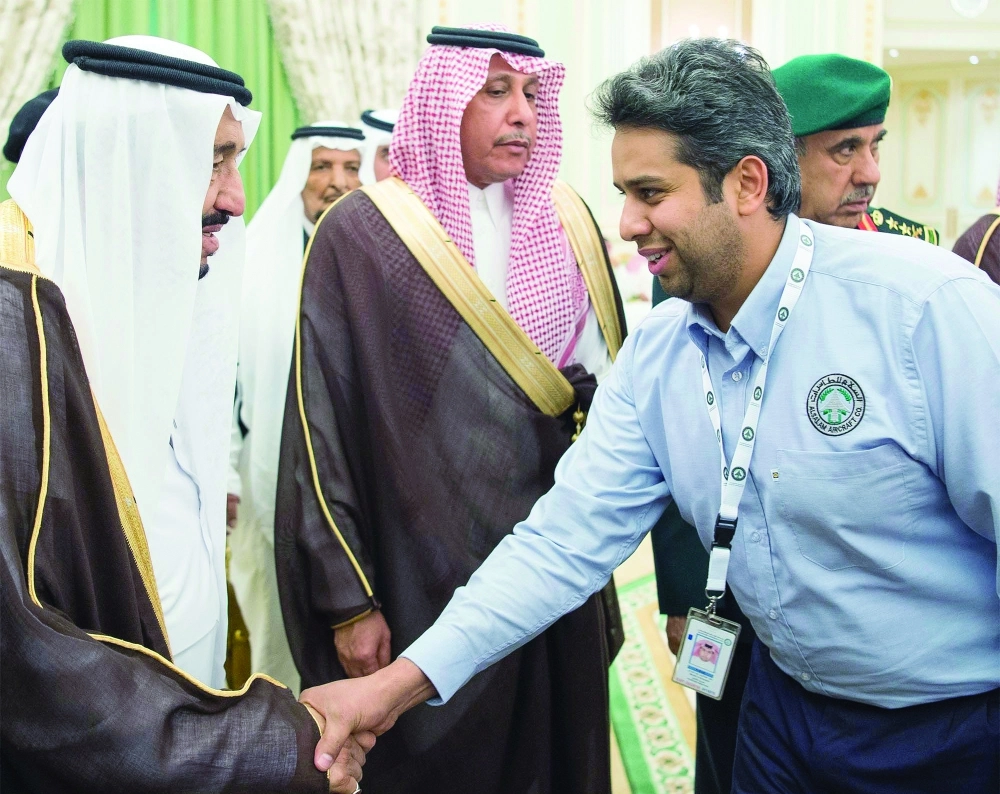 الملك سلمان مصافحا عددا من العاملين السعوديين