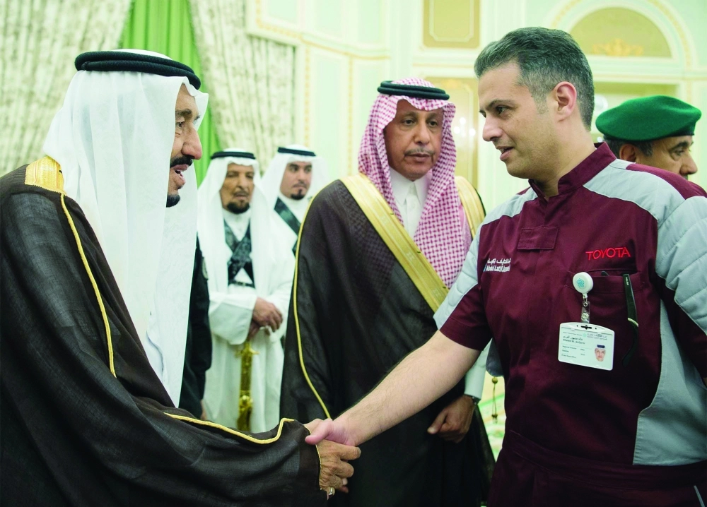 الملك سلمان مصافحا عددا من العاملين السعوديين