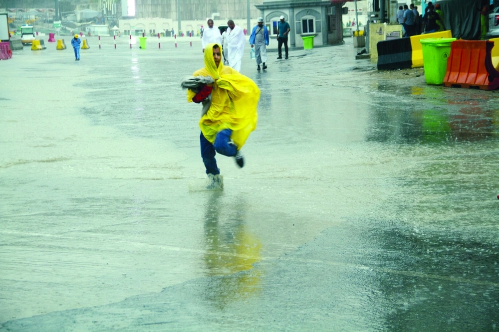  طفل يقطع أحد الشوارع هربا من الأمطار            (عبدالله الشنقيطي)