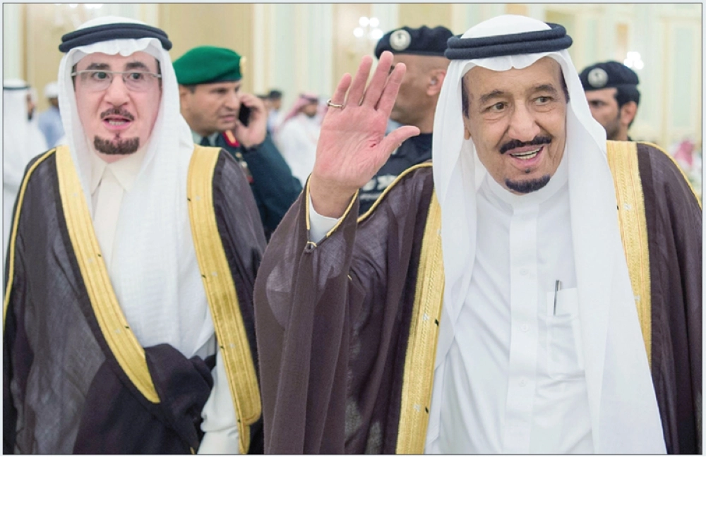 خادم الحرمين مرحبا بالحاضرين خلال لقائه مع وزير العمل وأصحاب المهن في الرياض أمس (واس)