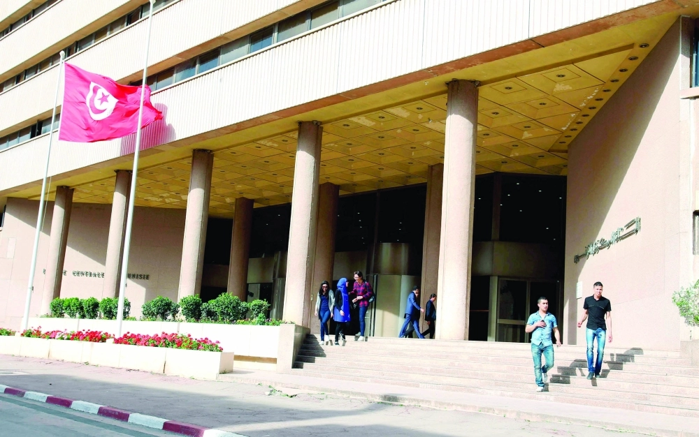 تونسيون يسيرون أمام مقر البنك المركزي التونسي                                              (رويترز)