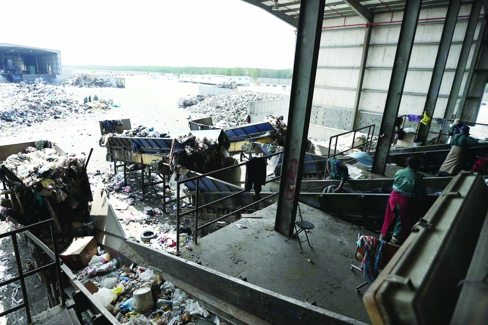  عمال خلال فرزهم النفايات وتنظيف الموقع في مردم جدة (ثامر الفرج)
