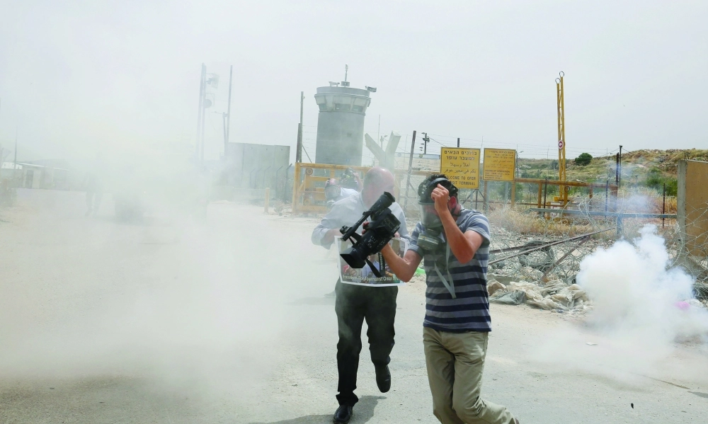 الاحتلال يطلق غازا مسيلا للدموع تجاه صحفيين في الضفة أمس                (أ ف ب)