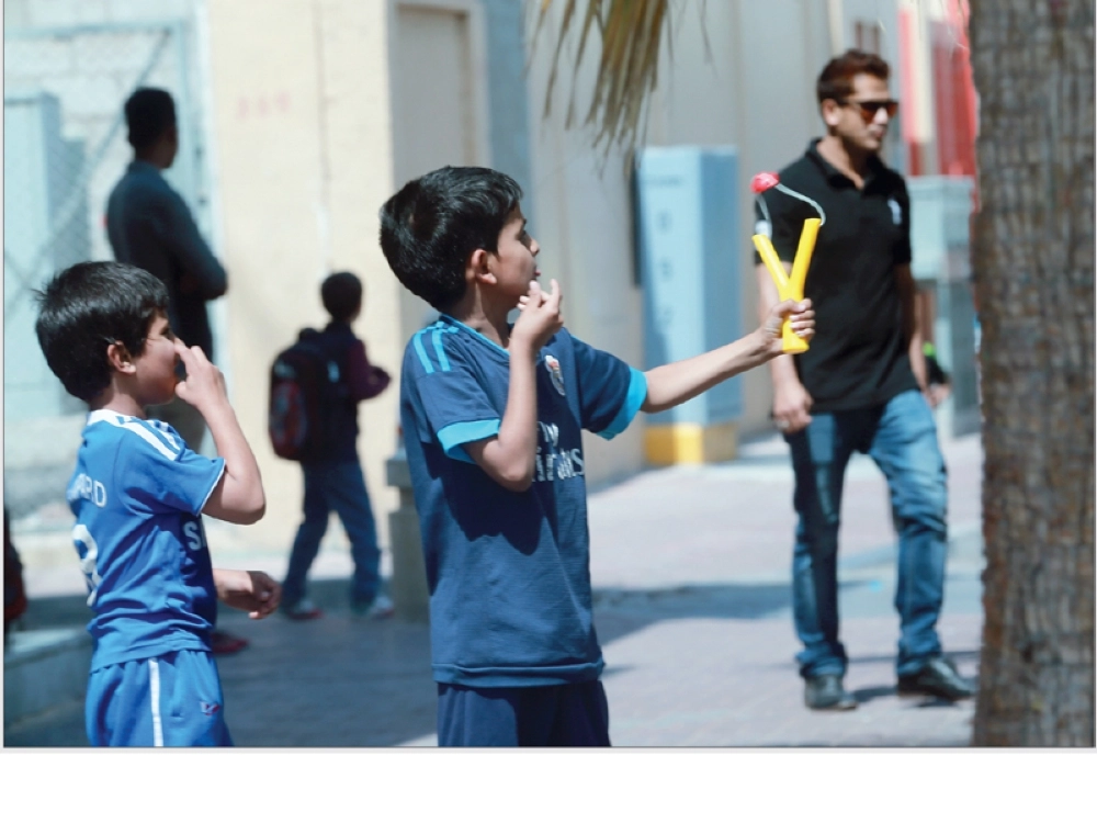 
طالب يتدرب على صيد الطيور بنبلة بعد خروجه من إحدى المدارس أمس الأول بحي السوق في الدمام (حمدان الدوسري) 